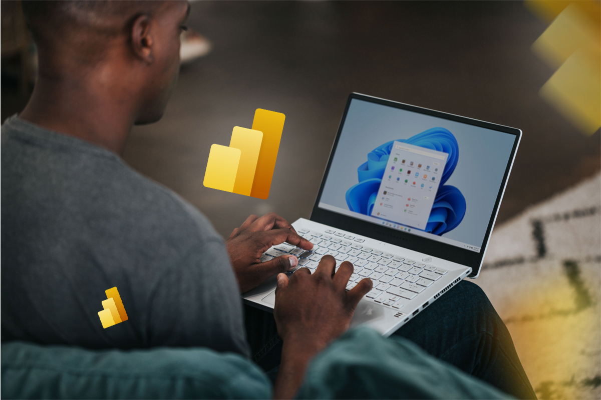 Homem de costas usa um computador na aba inicial do Windows. ícones do Power BI flutuam pela tela.
