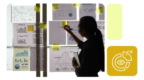 Profissional analisa gráficos e dados em painéis colados na parede, usando post-its e tablet, sugerindo tomada de decisão visual, com ícone alusivo à visualização de dados.