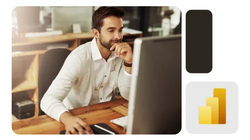 Homem usando suéter claro trabalha em frente a monitor desktop em escritório moderno e organizado, demonstrando foco; ícone do Power BI em destaque.