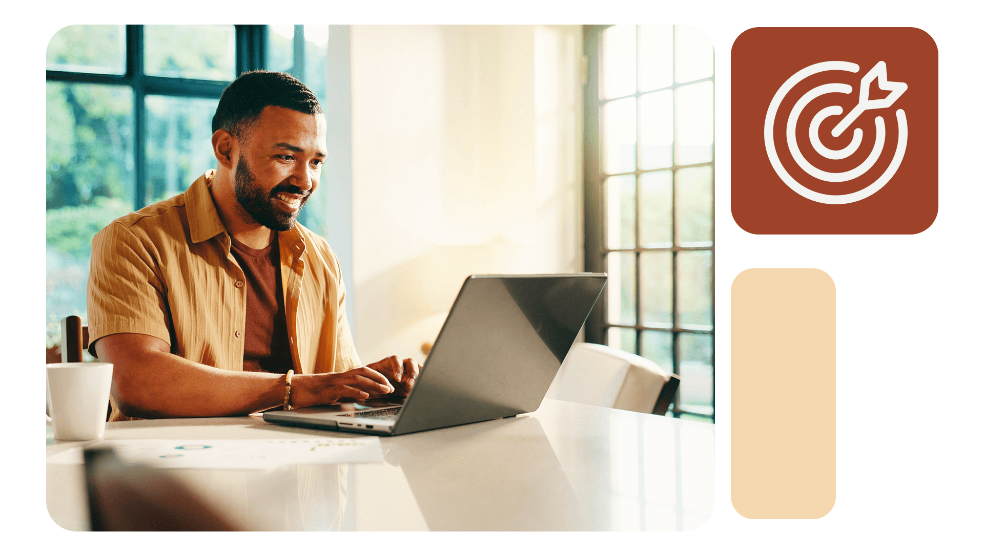 Homem sorrindo enquanto trabalha no notebook em ambiente iluminado, com ícone de alvo e flecha ao lado, simbolizando definição de metas claras.