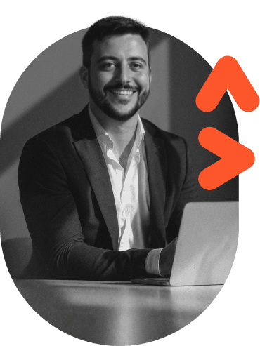 Filipe Maia, sócio-fundador da Lean Solutions, sorrindo à mesa com um notebook